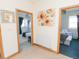 A hallway with beige carpet and two doorways leading to bedrooms at High Wood Foot in Bampton Cumbria