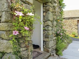 A garden with climbing plants and a stone wall at High Wood Foot in Bampton, Cumbria