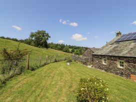 A garden with a building and tree at High Wood Foot in Bampton, Cumbria