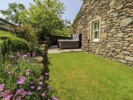 A garden with a hot tub and flowers at High Wood Foot in Bampton, Cumbria