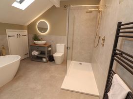 A bathroom with shower and bathtub at High Wood Foot in Bampton, Cumbria