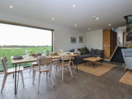 A dining room with a table and chairs at Tithe Barn Lodge Capel Mawr near Malltraeth