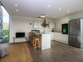 A kitchen with modern appliances and seating at Tithe Barn Lodge near Capel Mawr