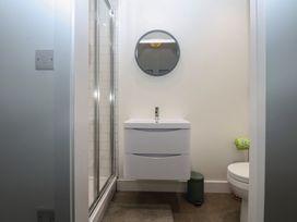 A bathroom with a shower, sink, and toilet at Tithe Barn Lodge Capel Mawr near Malltraeth