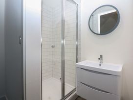 A bathroom with a shower and sink at Tithe Barn Lodge Capel Mawr near Malltraeth