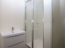 A bathroom with a shower and sink at Tithe Barn Lodge near Malltraeth