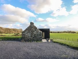 A stone and modern building with a gravel path at Tithe Barn Lodge Capel Mawr near Malltraeth
