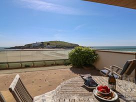 An outdoor patio with a table and chairs overlooking the sea at 6 Burgh Island in Bigbury-On-Sea