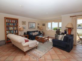 A living room with a bookshelf and sofas at 6 Burgh Island in Bigbury-On-Sea