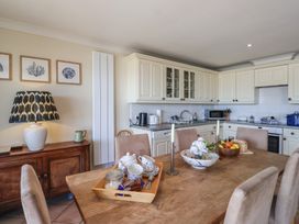 A kitchen with a dining table and fruits at 6 Burgh Island in Bigbury-On-Sea