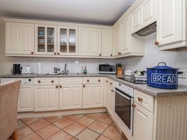 A kitchen with cabinets and appliances at 6 Burgh Island in Bigbury-On-Sea