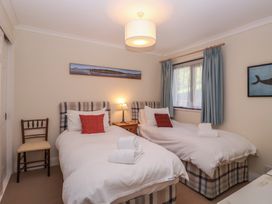 A bedroom with two single beds and a chair at 6 Burgh Island Bigbury-On-Sea