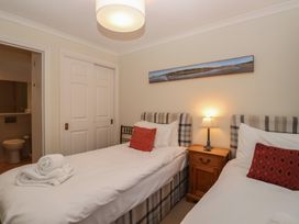 A bedroom with two beds and a nightstand at 6 Burgh Island Bigbury-On-Sea