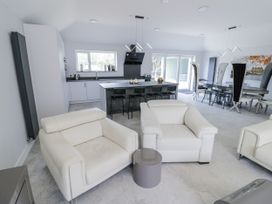 An open plan living area with a sofa and kitchen island at Chillon South Littleton near Honeybourne