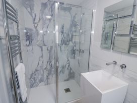A bathroom with a glass shower and a white sink at Chillon South Littleton near Honeybourne