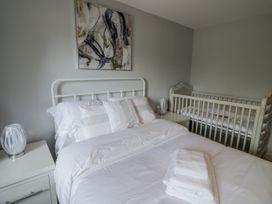 A bedroom with a bed and crib at Chillon South Littleton near Honeybourne