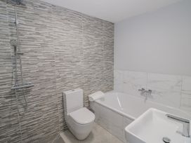 A bathroom with a bathtub, toilet, and sink at Chillon in South Littleton near Honeybourne
