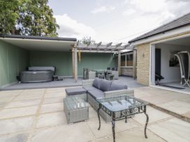 An outdoor living area with seating and a hot tub at Chillon South Littleton near Honeybourne