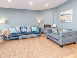 A living room with a sofa, armchair, and coffee table at 2 The Quay in Pentraeth
