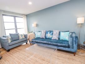 A living room with a sofa and armchair at 2 The Quay Pentraeth