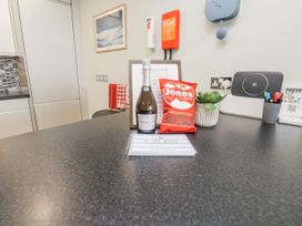 A kitchen counter with a bottle of prosecco and snacks at 2 The Quay Pentraeth