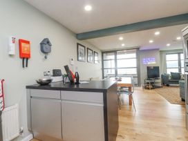 A kitchen with a dining area and living space at 2 The Quay Pentraeth