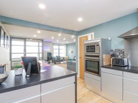 A kitchen with appliances and a dining area at 2 The Quay Pentraeth