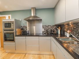 A kitchen with modern appliances and fixtures at 2 The Quay Pentraeth
