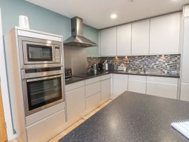 A kitchen with oven, sink and cabinets at 2 The Quay Pentraeth