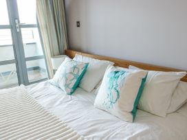 A bedroom with a bed and decorative pillows at 2 The Quay in Pentraeth
