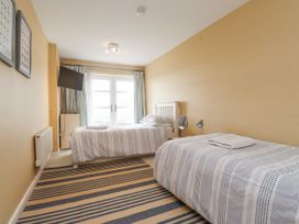 A bedroom with two beds and a television at 2 The Quay in Pentraeth