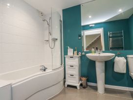 A bathroom with a bathtub, shower, sink, and toilet at 2 The Quay Pentraeth