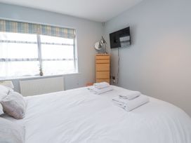 A bedroom with a bed and a television at 2 The Quay Pentraeth
