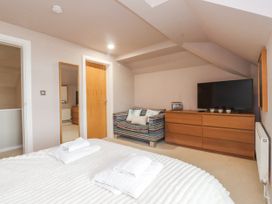 A bedroom with a bed and television at 2 The Quay Pentraeth