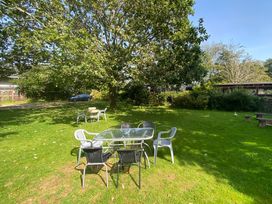 A garden with a table and chairs under a tree at Garden Flat Porthmadog
