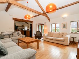 A living room with two sofas a wooden coffee table and exposed wooden beams at Mistletoe Cottage Kemeys Commander near Usk