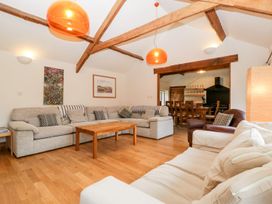 A living room with sofas coffee table and exposed wooden beams at Mistletoe Cottage in Kemeys Commander near Usk