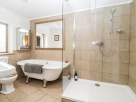 A bathroom with a bathtub mirror shower and toilet at Mistletoe Cottage in Kemeys Commander near Usk