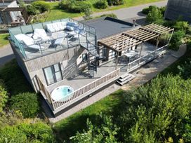 A house with an outdoor seating area and hot tub at The Black Barnacle in Portreath