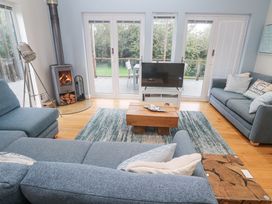 A living room with a fireplace and sliding doors at The Black Barnacle in Portreath