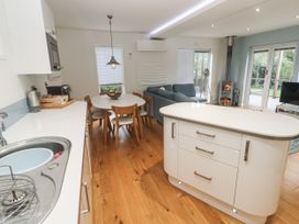 A kitchen and dining area with an island, dining table, and sofa at The Black Barnacle in Portreath