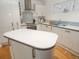 A kitchen with a central island and modern appliances at The Black Barnacle in Portreath