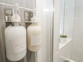 A body wash and shampoo mounted on a wall in a bathroom at The Black Barnacle in Portreath