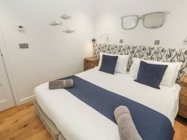 A bedroom with a bed and wooden furniture at The Black Barnacle in Portreath