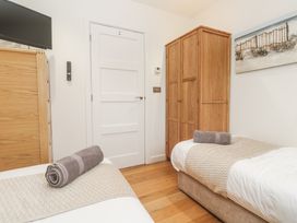 A bedroom with two single beds and a wardrobe at The Black Barnacle in Portreath