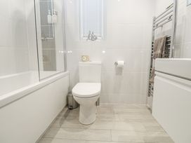 A bathroom with a toilet, bath, and towel rack at The Black Barnacle in Portreath