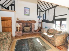 A living room with two sofas a fireplace and a bookshelf at Wyre Court Cottage in Bewdley