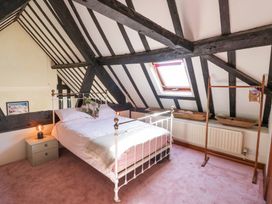 A bedroom with a metal bed frame nightstand and wooden clothes rack under a skylight at Wyre Court Cottage in Bewdley