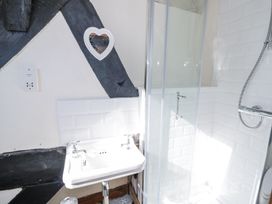 A bathroom with a white sink and a glass shower enclosure at Wyre Court Cottage in Bewdley