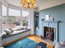 A living room with a fireplace and window seat at Isla House in Whitby
